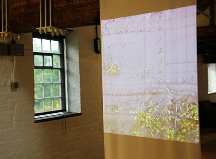 A projection of moss growing over an old handwritten wages book
