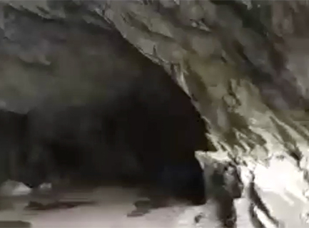 blurry darkness behind a rocky entrance to the back of a cave