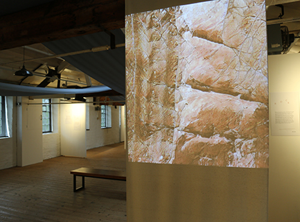 A projected image of rocks made with machine learning software, in an old mill building